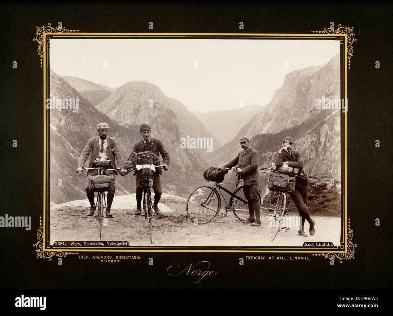 Dieses Foto zeigt Touristen, die Velocipedes (frühe Fahrräder) in Nærøy-dalen, Sogn og Fjordane, Norwegen fahren, aufgenommen vom Fotografen Axel Lindahl. Das Bild zeigt die beliebte Freizeitaktivität des Radfahrens im frühen 20. Jahrhundert vor der atemberaubenden norwegischen Landschaft. Stockfoto