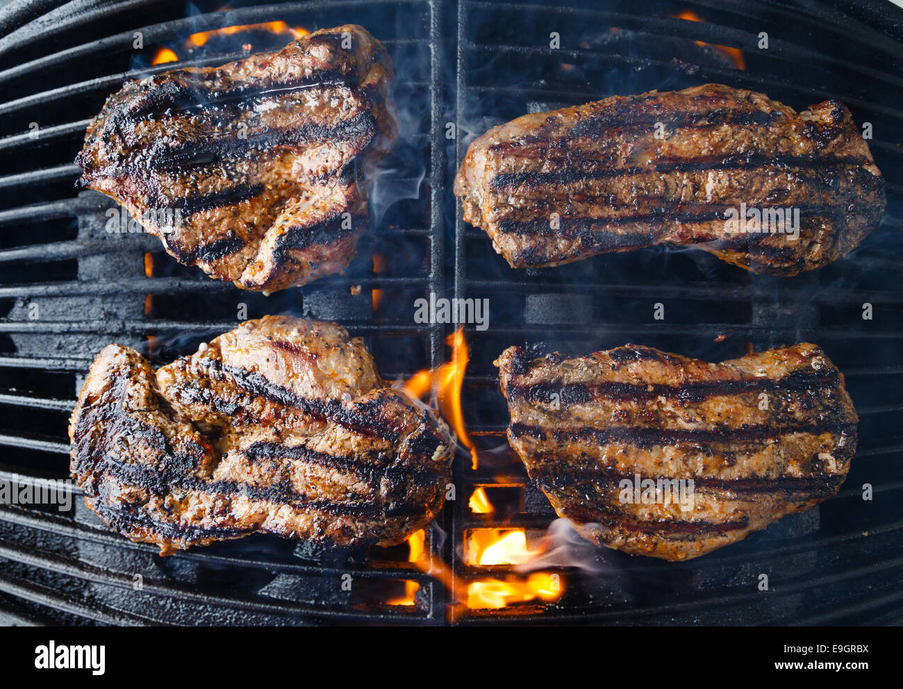 Steaks auf dem Grill, über Flamme gegrillt wird Char. Stockfoto