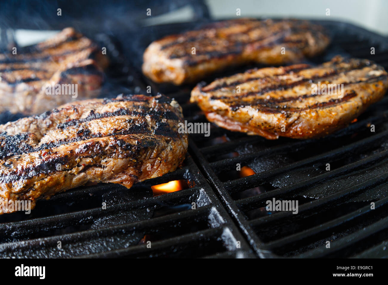 Steaks auf dem Grill, über Flamme gegrillt wird Char. Stockfoto