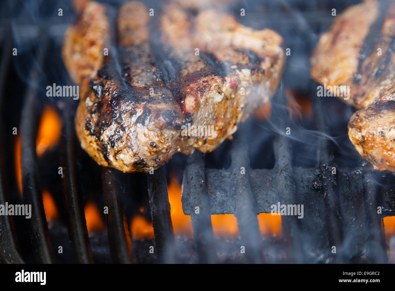 Steaks auf dem Grill, über Flamme gegrillt wird Char. Stockfoto