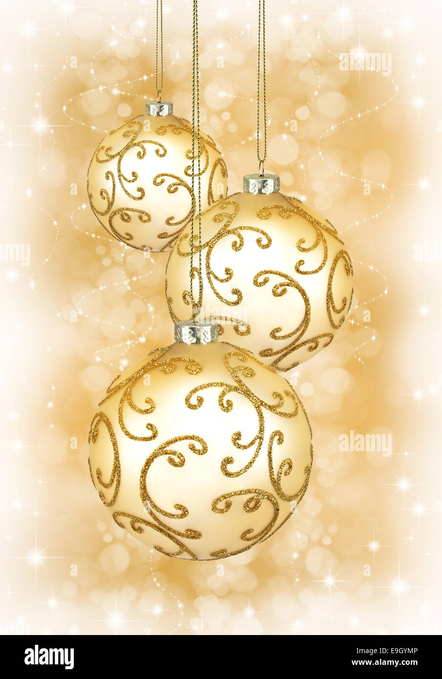 Drei schöne goldene Weihnachtskugeln auf goldenem Hintergrund Stockfoto