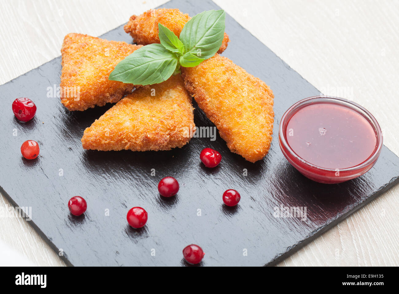 Gebratene Käse-Sticks, serviert mit Preiselbeeren, Sauce auf schwarzem ...