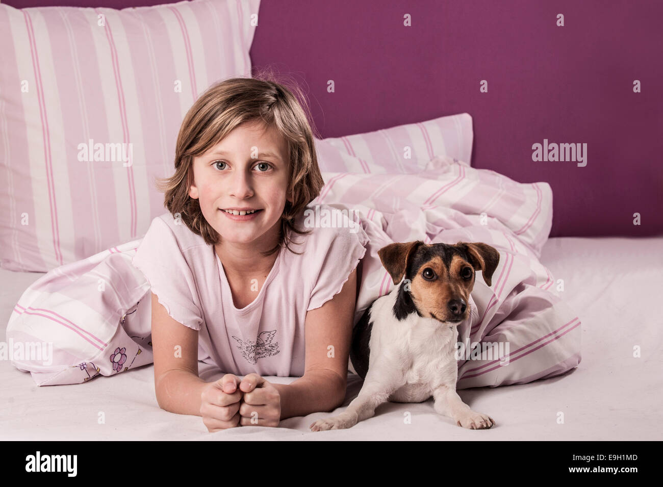 Mädchen im Bett mit einem Dänisch schwedischer Hofhund Stockfoto
