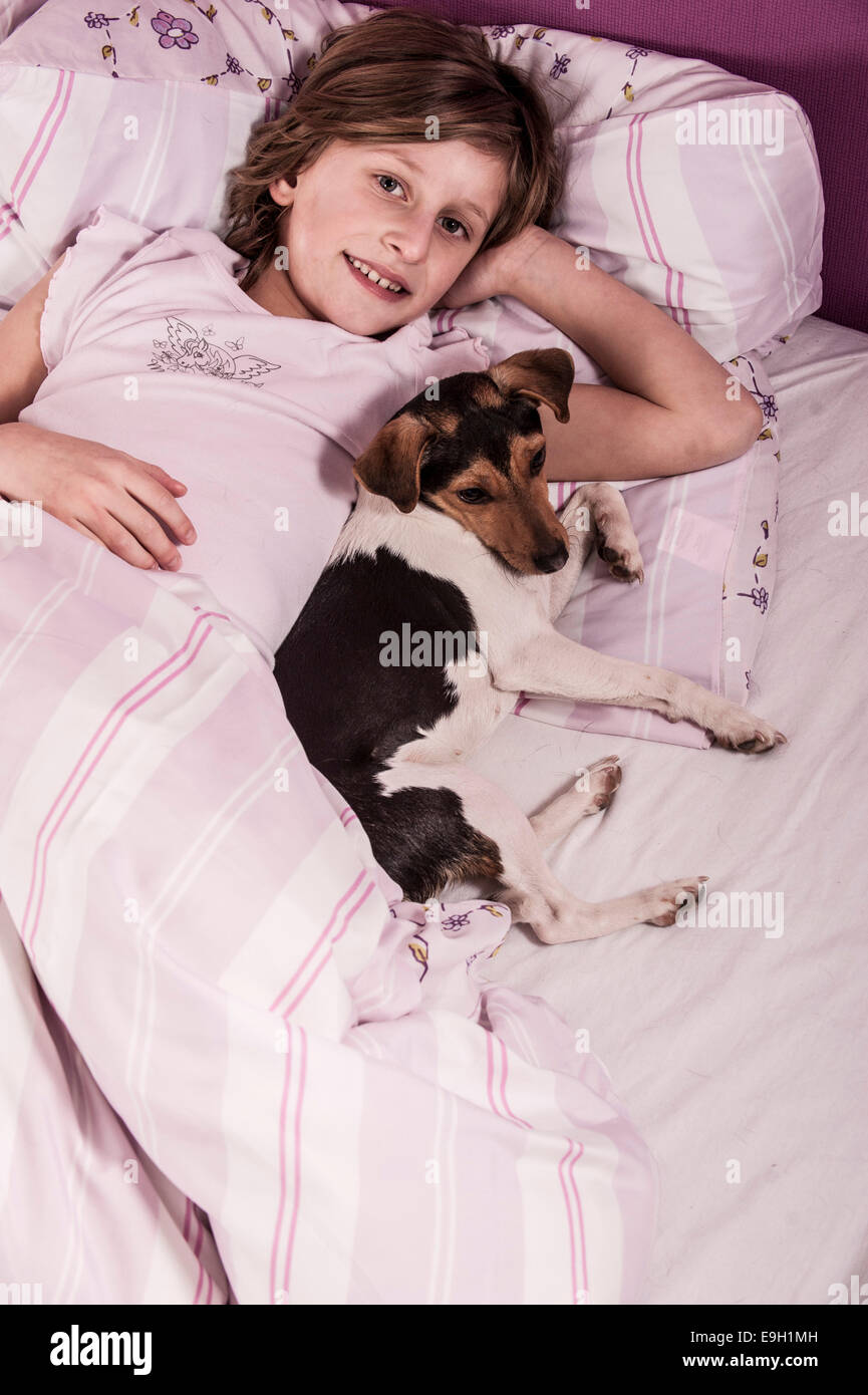 Mädchen im Bett mit einem Dänisch schwedischer Hofhund Stockfoto