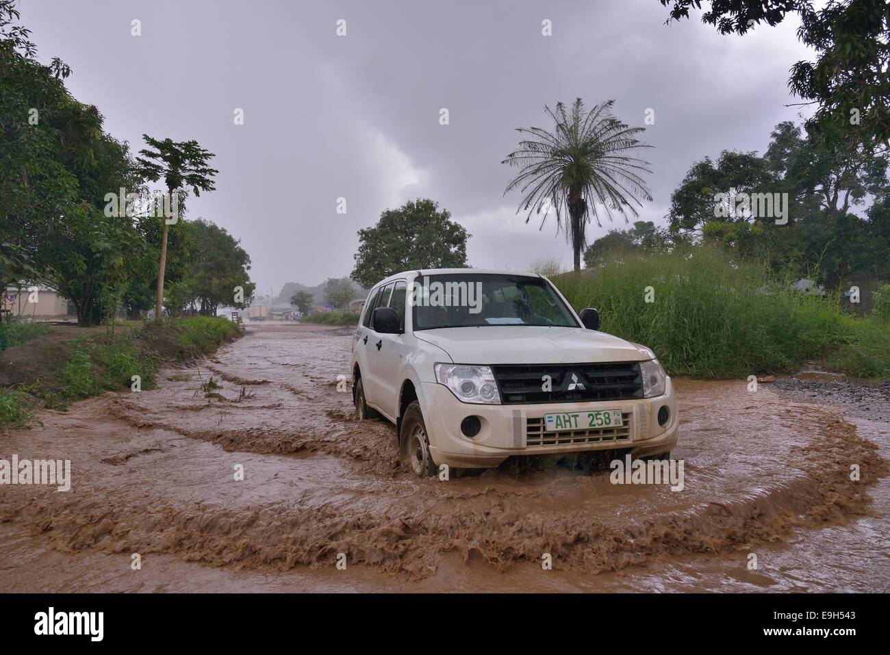 Auto fahren in einer überfluteten Straße während der regnerischen Jahreszeit, in der Nähe von Makeni, Bombali Bezirk, Sierra Leone Stockfoto