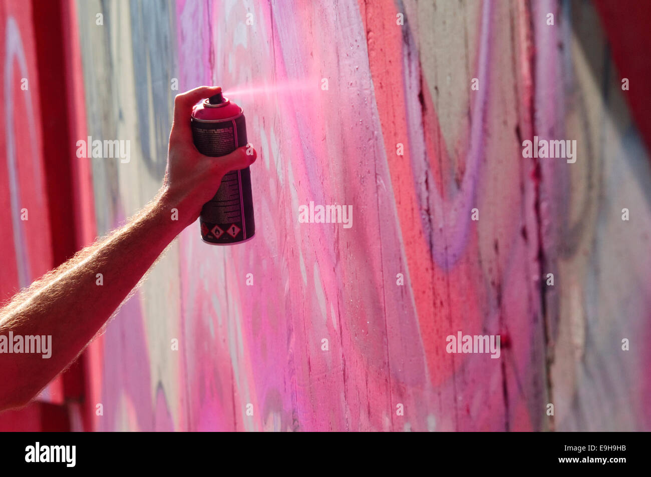 Hand hält eine Spraydose, Graffiti-Künstler an der Wand. Stockfoto