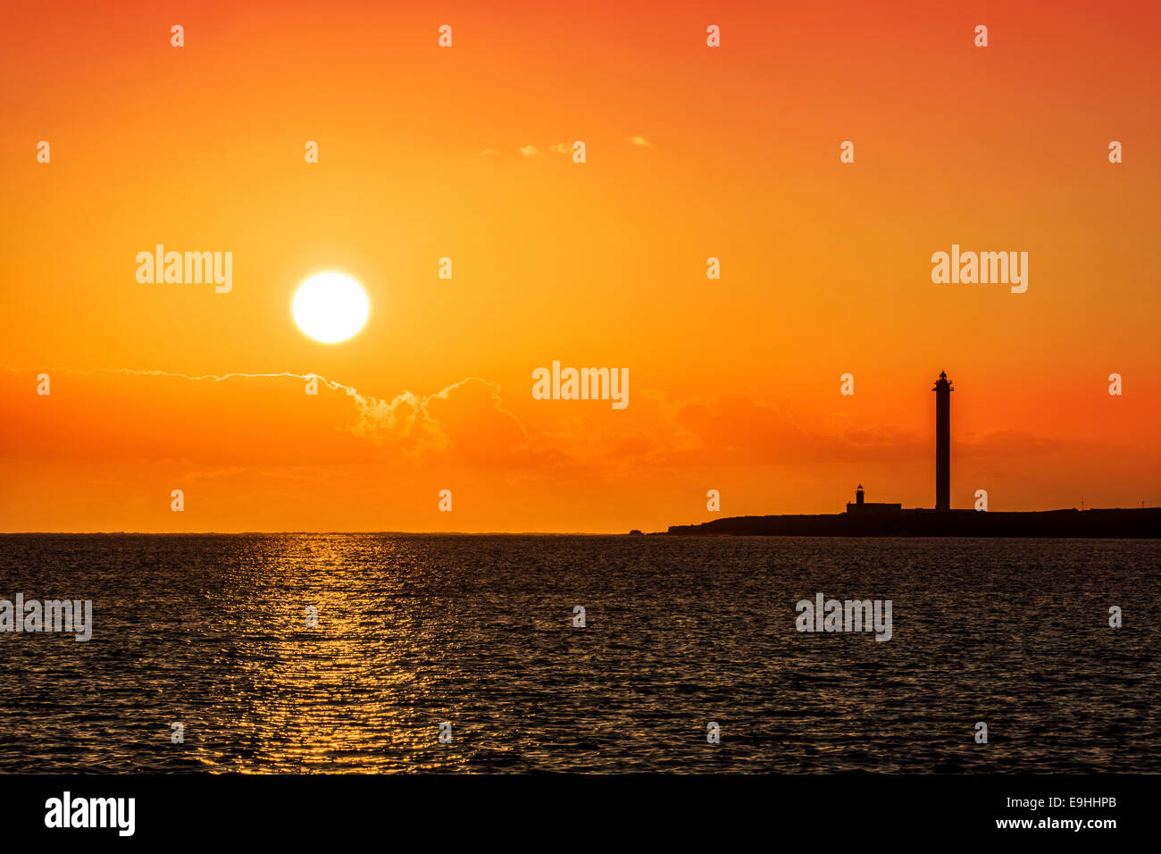 Schöne Lanzarote Sonnenuntergang gießen Land und Leuchtturm in Silhouette. Stockfoto