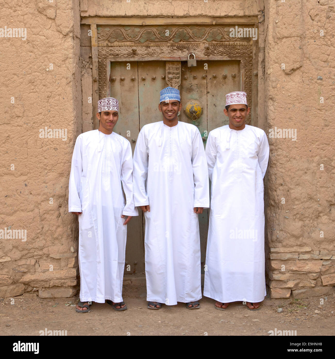 Drei junge omanischen Männer in traditioneller Kleidung bei den Ruinen von Birkat Al Mouz im Bereich Nizwa des Sultanats Oman. Stockfoto