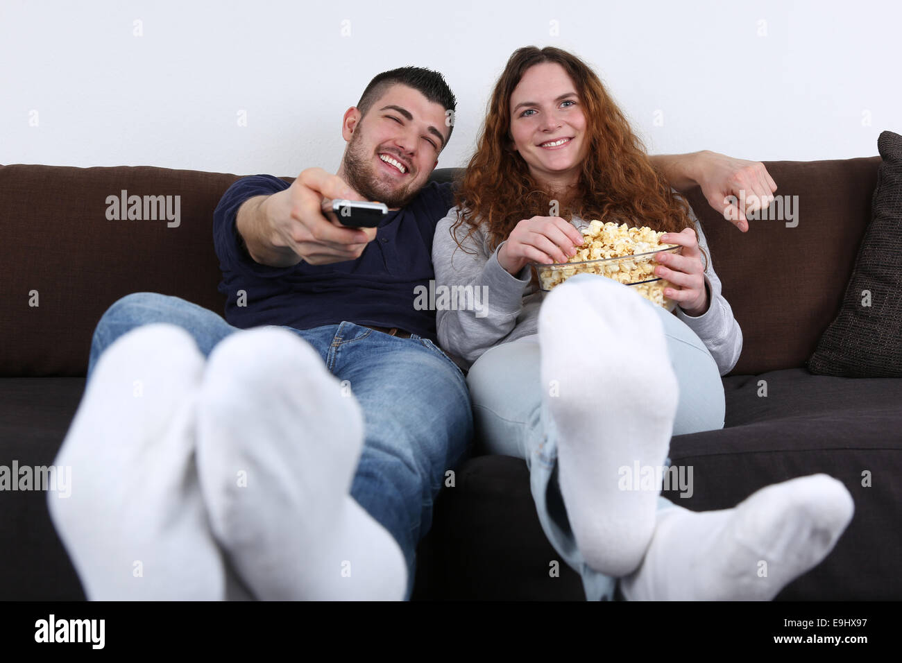 Junge Menschen, die Spaß beim Fernsehen und Essen popcorn Stockfoto