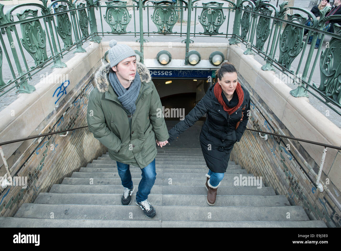 Touristen und Pendler verlassen Sie eine Pariser U-Bahnhof im Winter mit großen Mäntel auf Grund der kalten Stockfoto