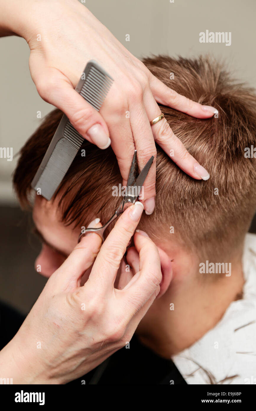 Junger Mann mit einem Haarschnitt an einen Friseur Stockfoto