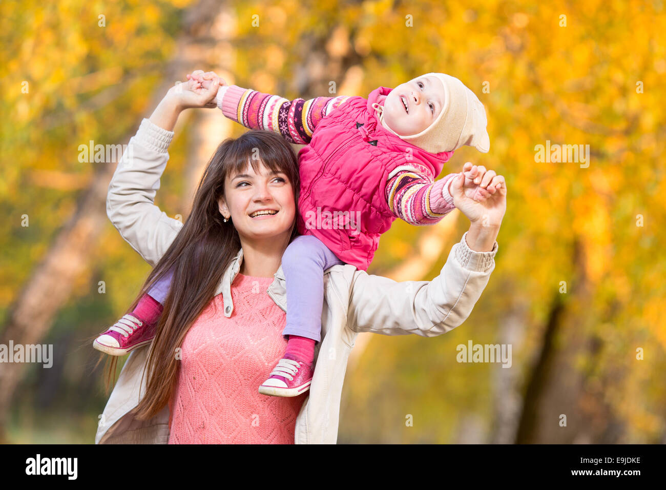 schöne Frau mit Kind Mädchen im Freien im herbstlichen park Stockfoto