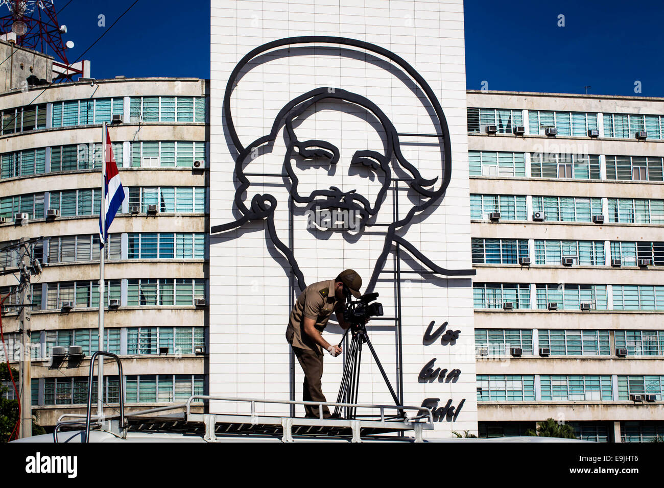 Havanna, Kuba. 28. Oktober 2014. Ein Kameramann ist vor dem Gebäude mit Camilo Cienfuegos Porträt in Havanna, die Hauptstadt von Kuba, am 28. Oktober 2014 gesehen. Tausende von Kubaner marschierten vom revolutionären Platz zum Meer, Blumen zum Gedenken an Camilo Cienfuegos am Dienstag anzubieten. Kuba am Dienstag markiert den 55. Jahrestag des Todes von Camilo Cienfuegos. Camilo, zusammen mit Fidel Castro und Che Guevara, sind die drei Chef Kommandeure der kubanischen Revolution. Er starb in einem Flug-Unfall im Alter von 27. Bildnachweis: Liu Bin/Xinhua/Alamy Live-Nachrichten Stockfoto