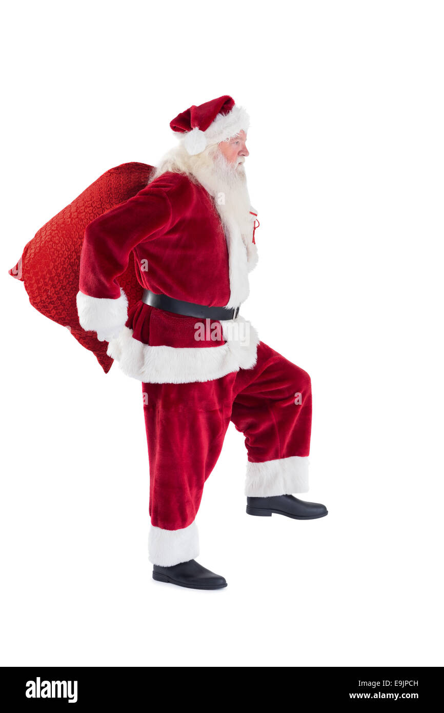 Santa trägt seine rote Tasche Stockfoto