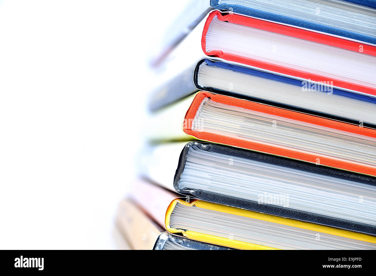 Mehrfarbige gestapelte Bücher auf weißem Hintergrund Stockfoto