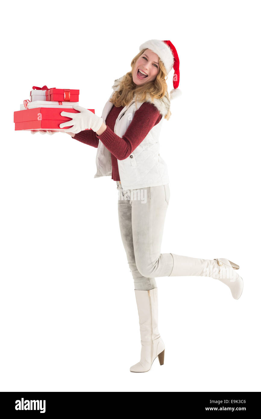 Lächelnde Blondine in warme Kleidung mit Haufen von Geschenken Stockfoto