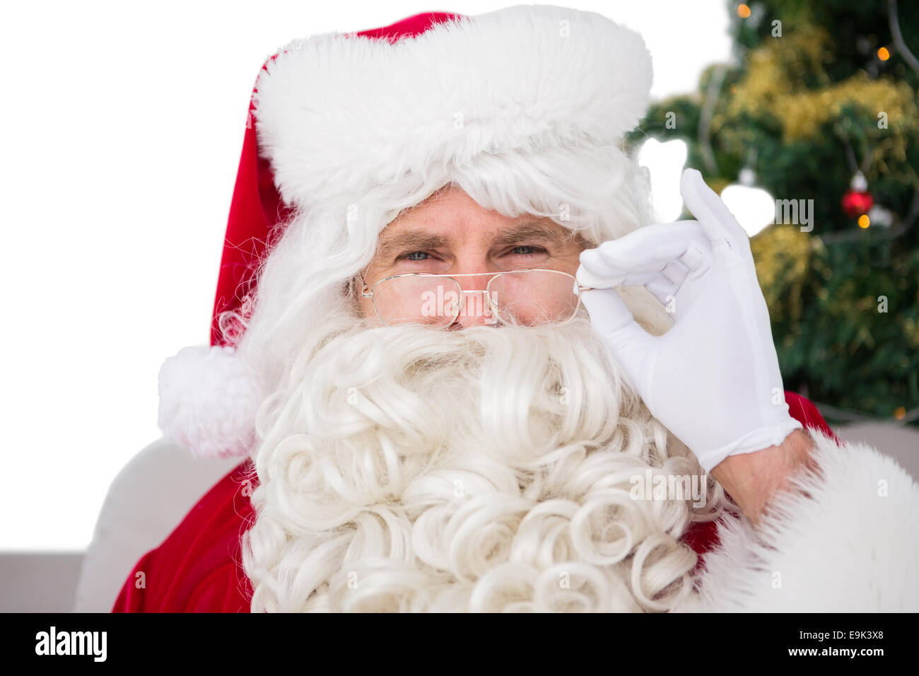 Ratlos Weihnachtsmann hält seine Brille Stockfoto