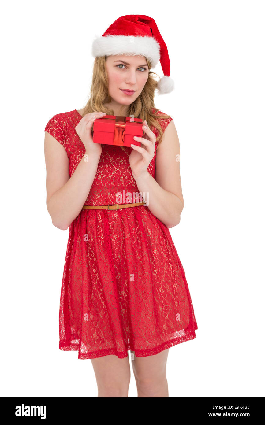 Blonde Frau in Santa Hut Stand mit Geschenk Stockfoto