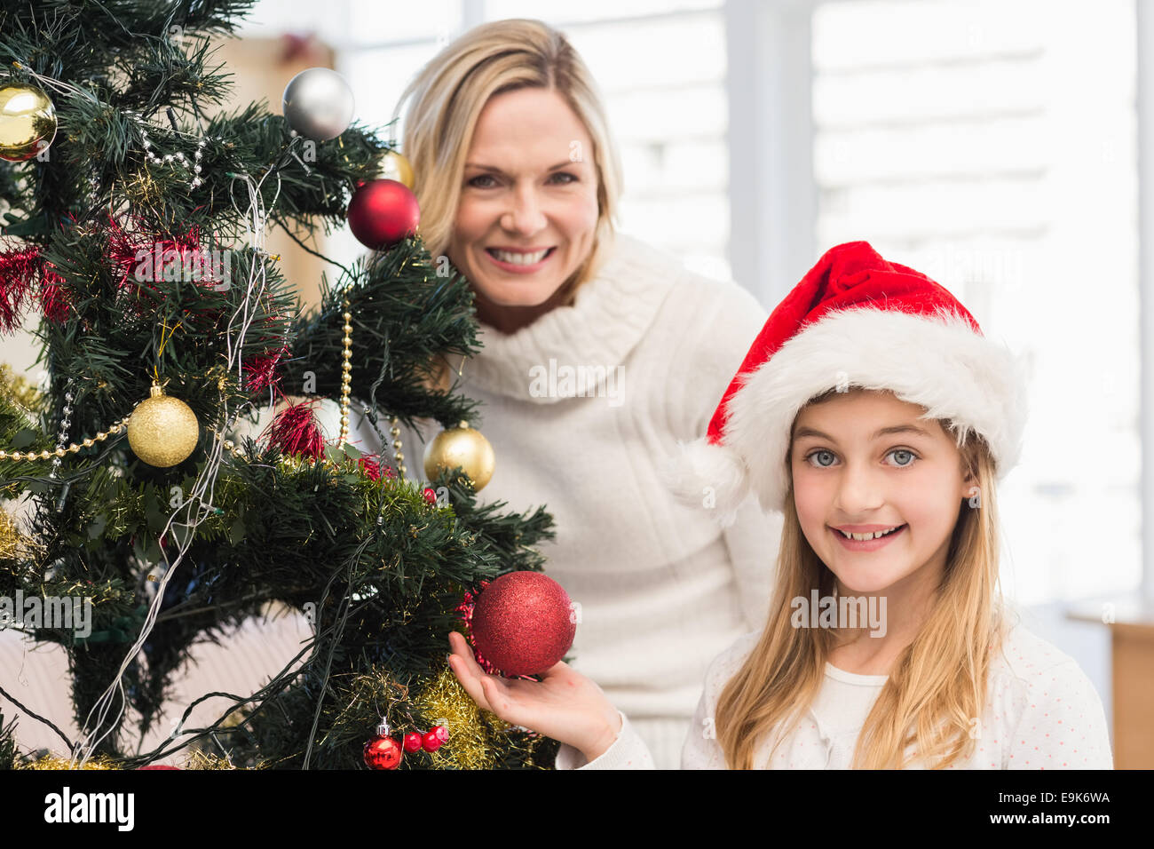 Festliche Mutter und Tochter schmücken Weihnachtsbaum Stockfoto