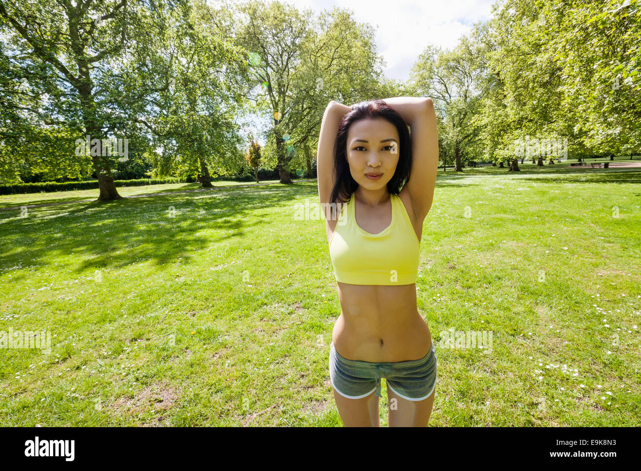 Porträt des jungen Fit Frau stretching am park Stockfoto