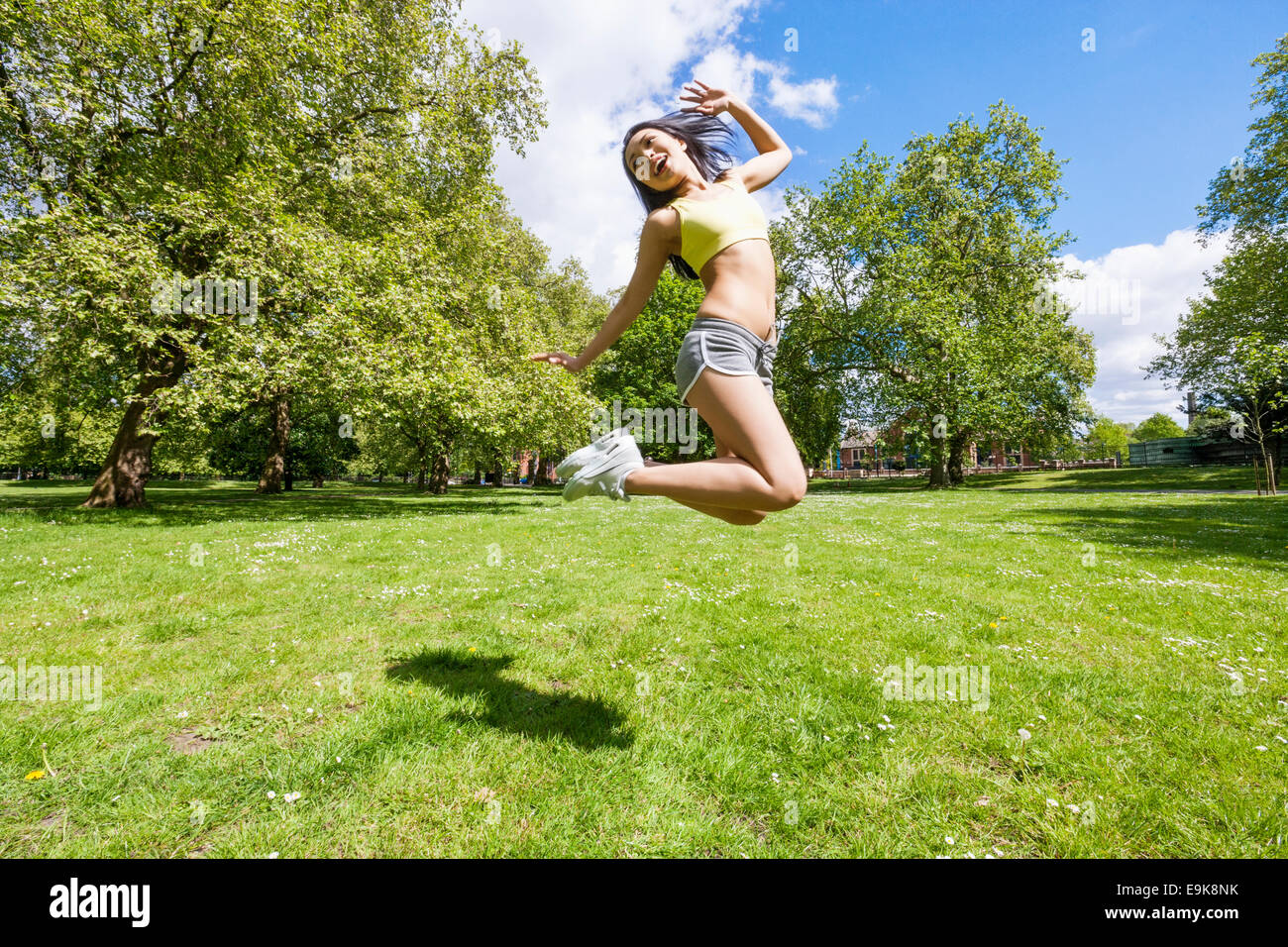Voller Länge glücklich Fit Frau springen im park Stockfoto