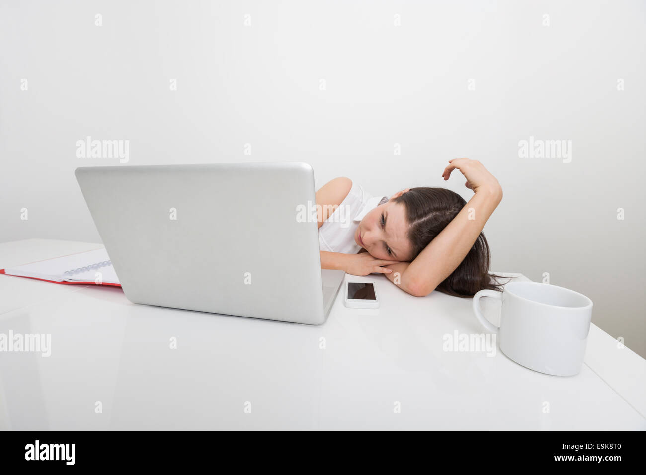 Gelangweilte Geschäftsfrau Blick auf Laptop im Büro Stockfoto