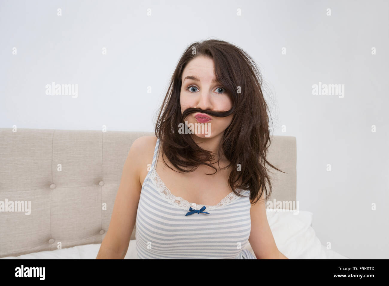 Portrait von verspielte Frau mit Schnurrbart, Haare im Bett gemacht Stockfoto