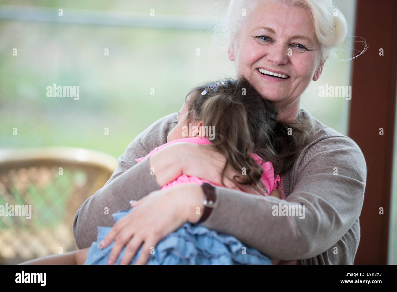 Porträt der glückliche Oma umarmt Enkelin im Haus Stockfoto