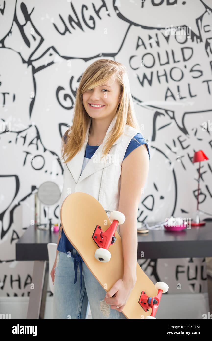 Porträt von glücklich Teenager-Mädchen halten Skateboard zu Hause Stockfoto