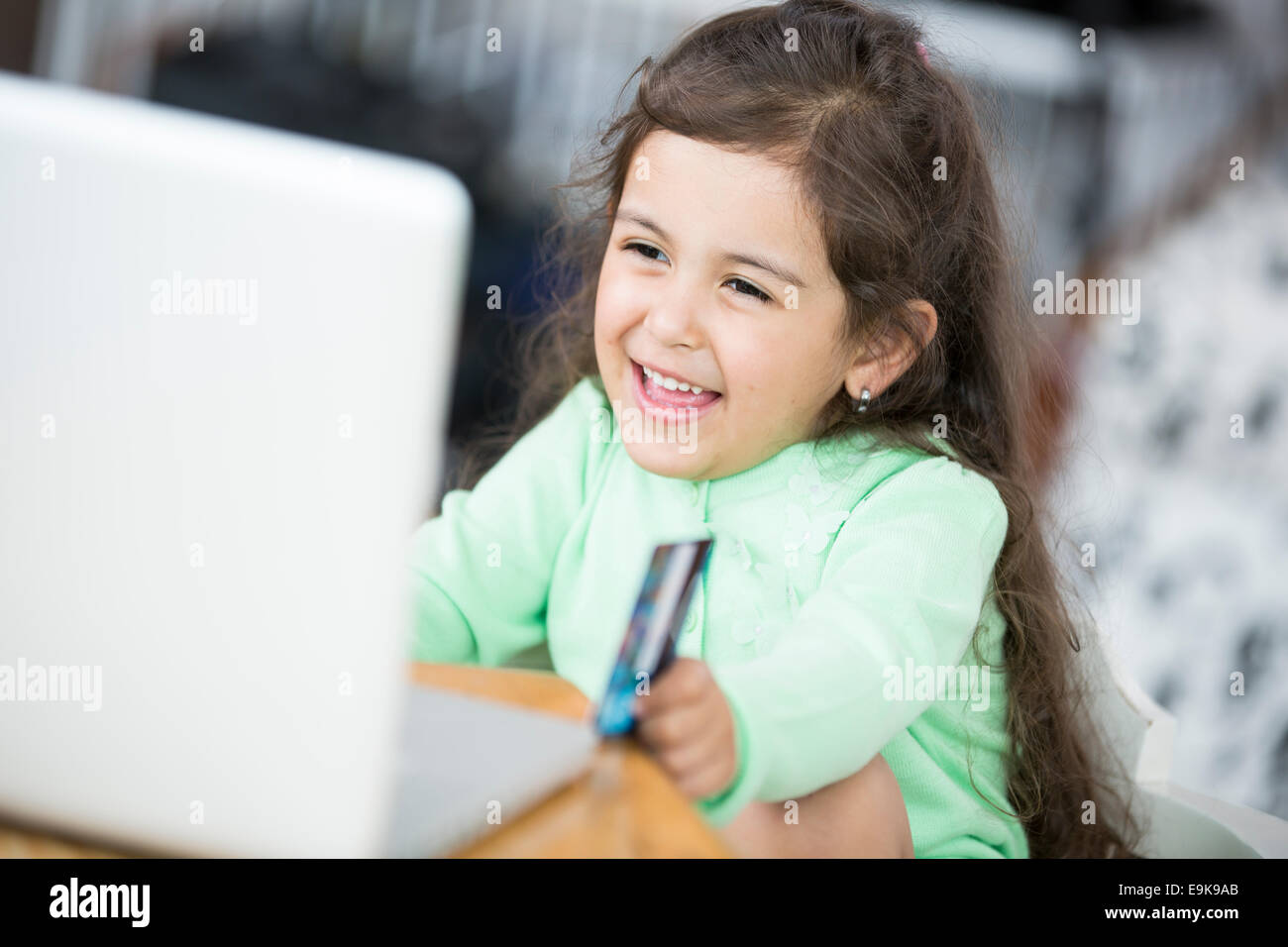 Glückliches Mädchen mit Laptop und Kreditkarte zum Online-shop zu Hause Stockfoto