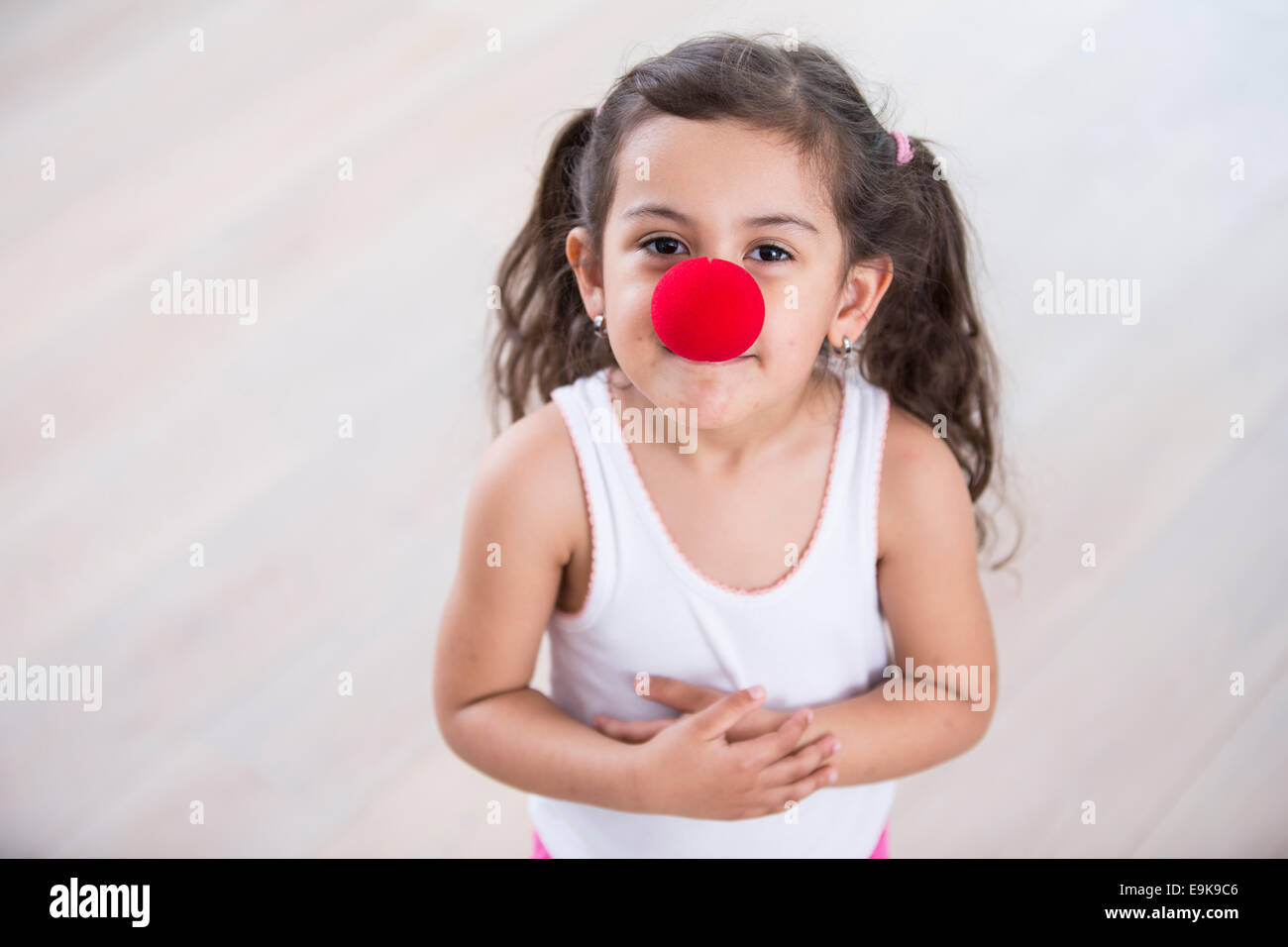 Porträt der niedliche kleine Mädchen tragen Clownsnase zu Hause Stockfoto