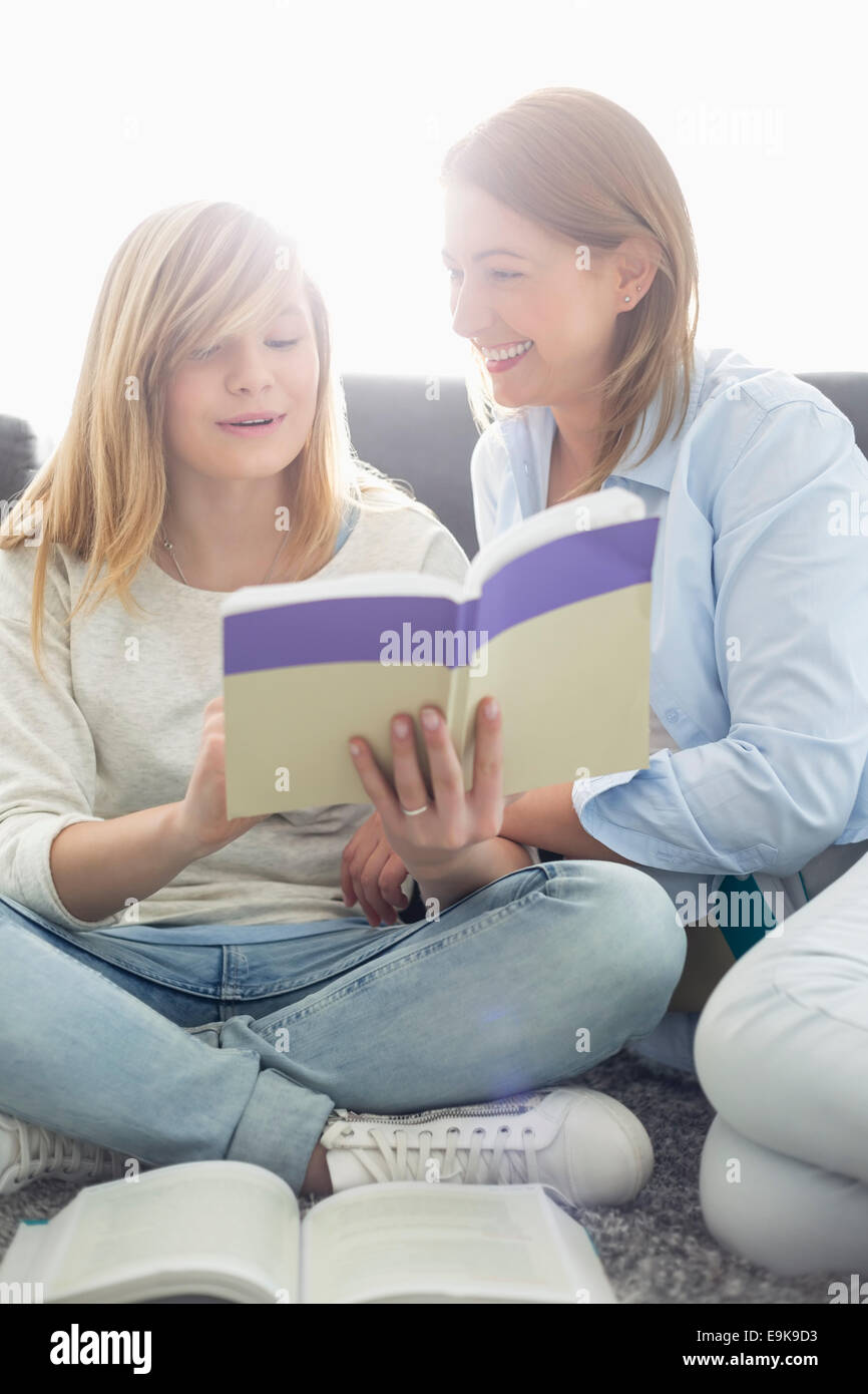 Mutter Mitarbeitende Tochter in Hausaufgaben zu Hause Stockfoto
