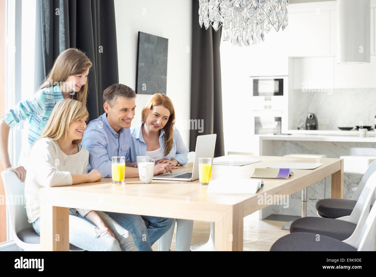 Glückliche Familie von vier mit Laptop zu Hause Stockfoto