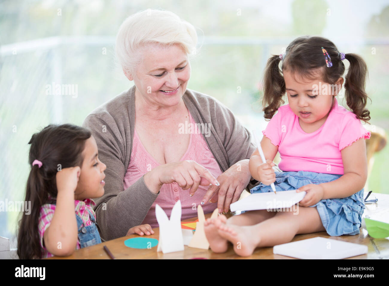 Beautiful senior Woman helfen Enkelinnen, Handwerk zu Hause Stockfoto