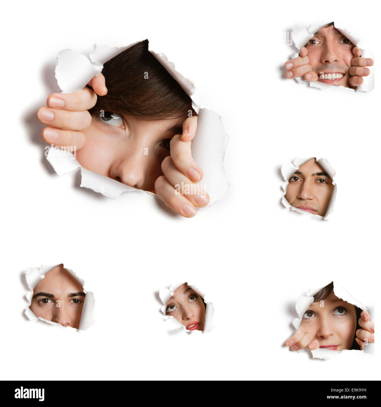 Multiethnische erfolgte durch zerrissene Papier Löcher Stockfoto