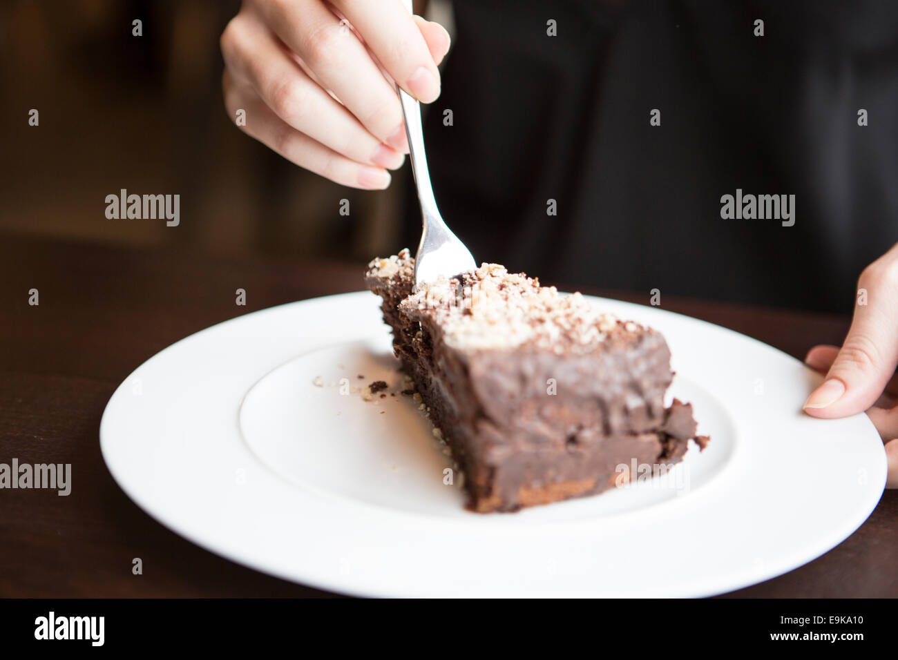 Nahaufnahme von Frauenhand schneiden Schokolade Gebäck Stockfoto