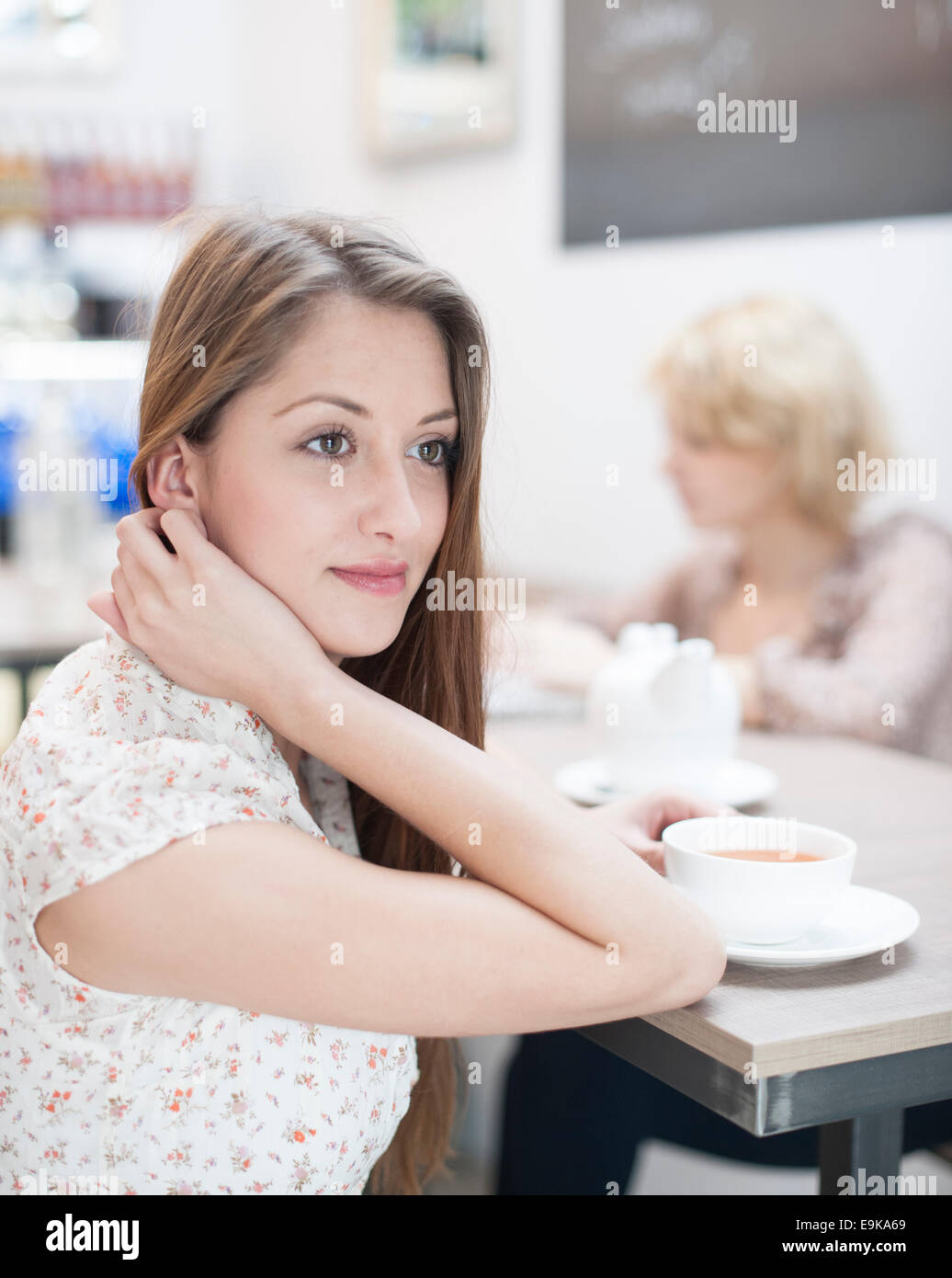 Nachdenkliche junge Frau mit Kaffee im café Stockfoto