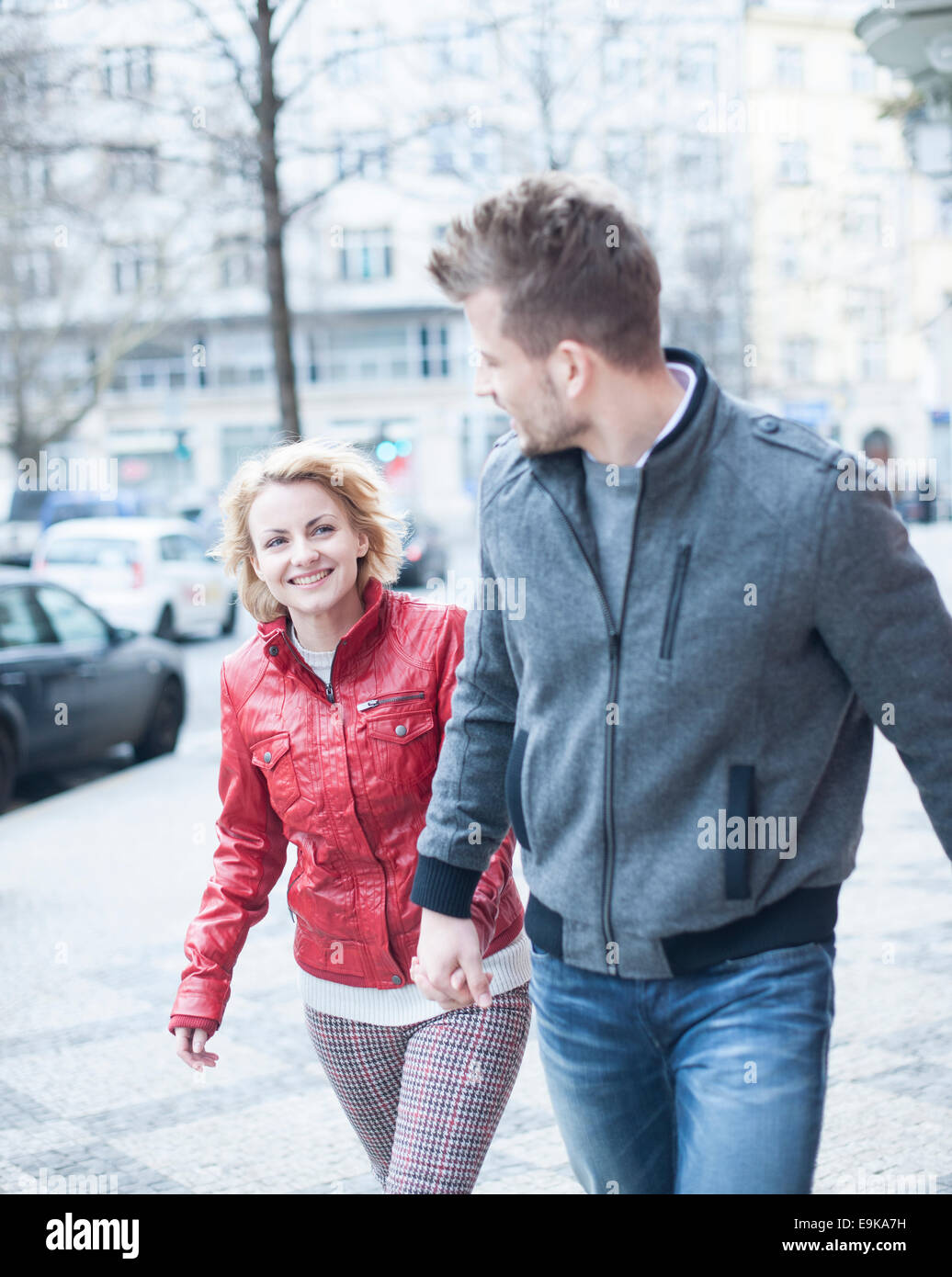 Glückliches junges Paar Hand in Hand während des Gehens auf Stadtstraße Stockfoto