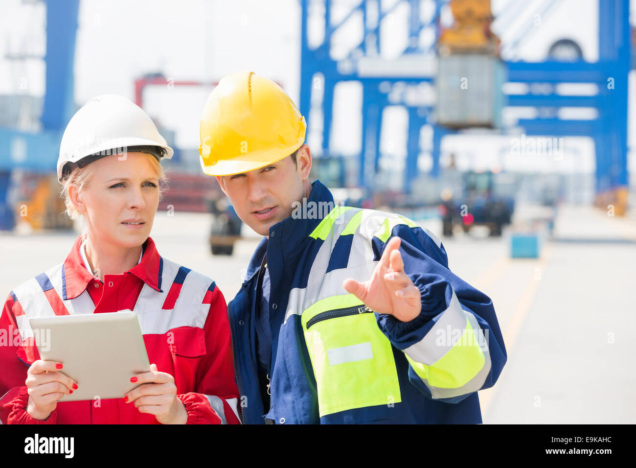 Arbeitnehmerinnen und Arbeitnehmer im Frachthafen diskutieren Stockfoto