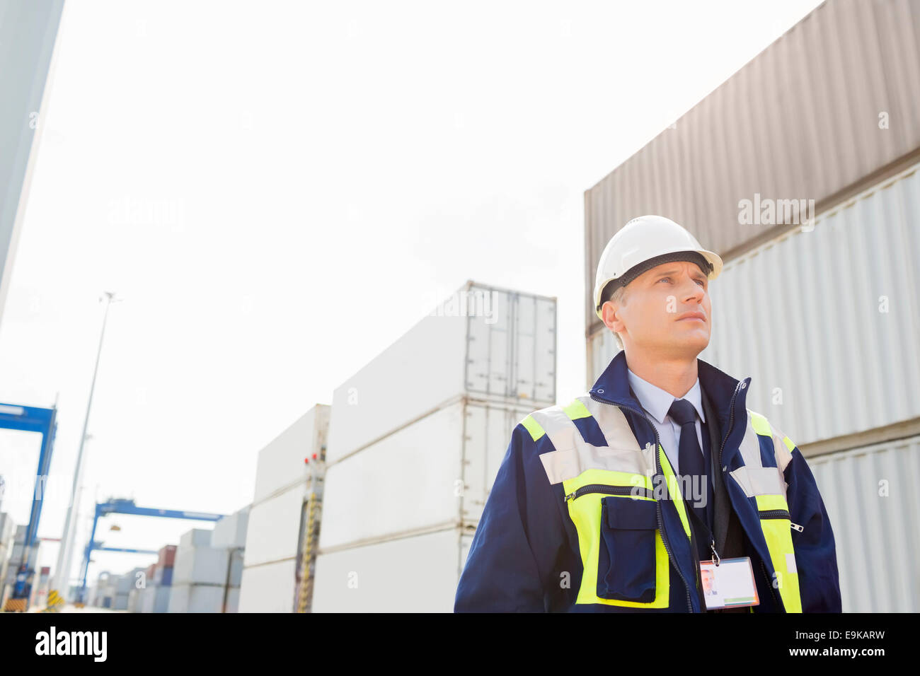 Im mittleren Alter männlicher Arbeitnehmer im Frachthafen wegschauen Stockfoto