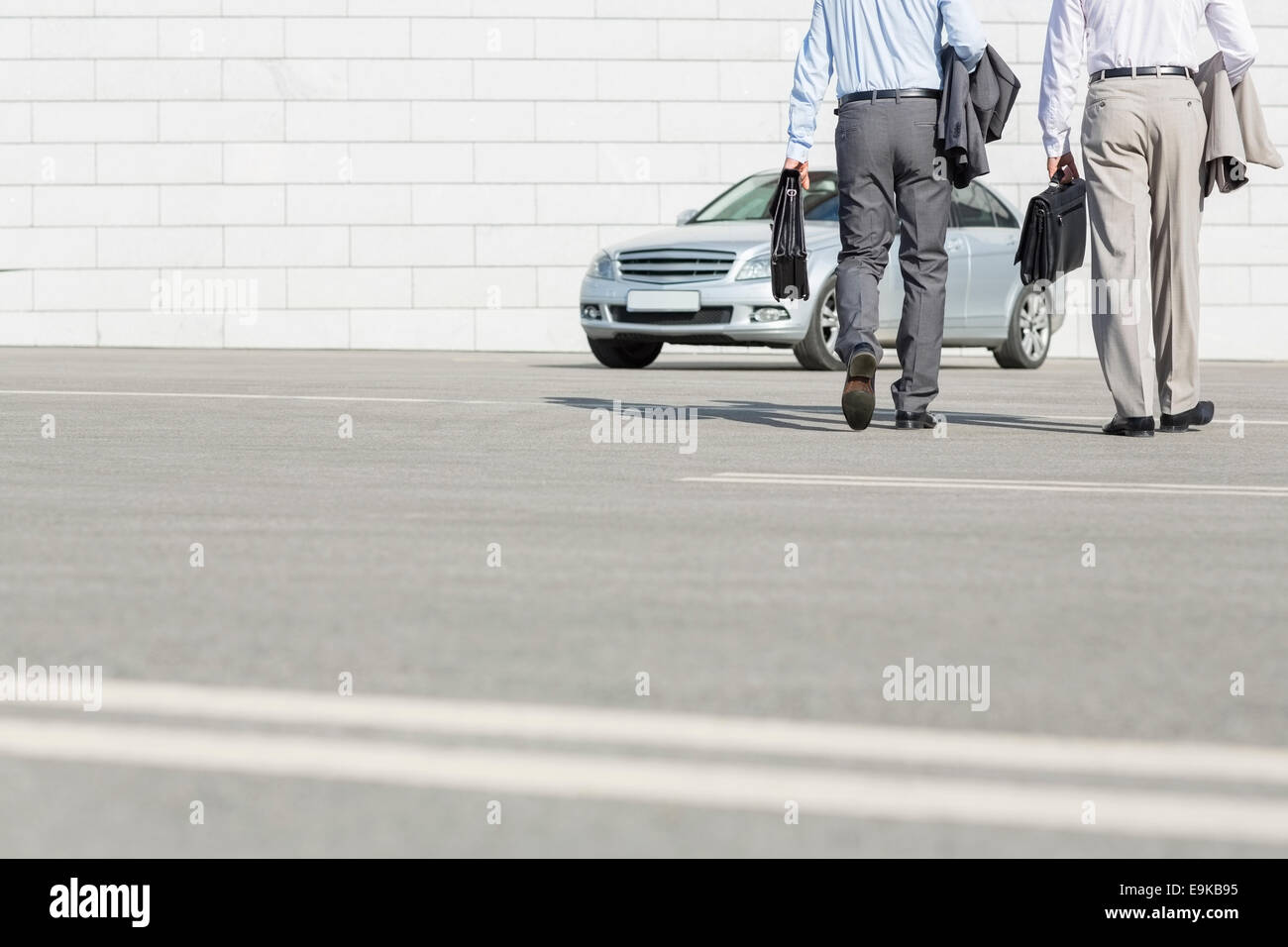 Geringen Teil der Geschäftsleute tragen Aktentaschen während des Gehens auf Auto auf der Straße Stockfoto