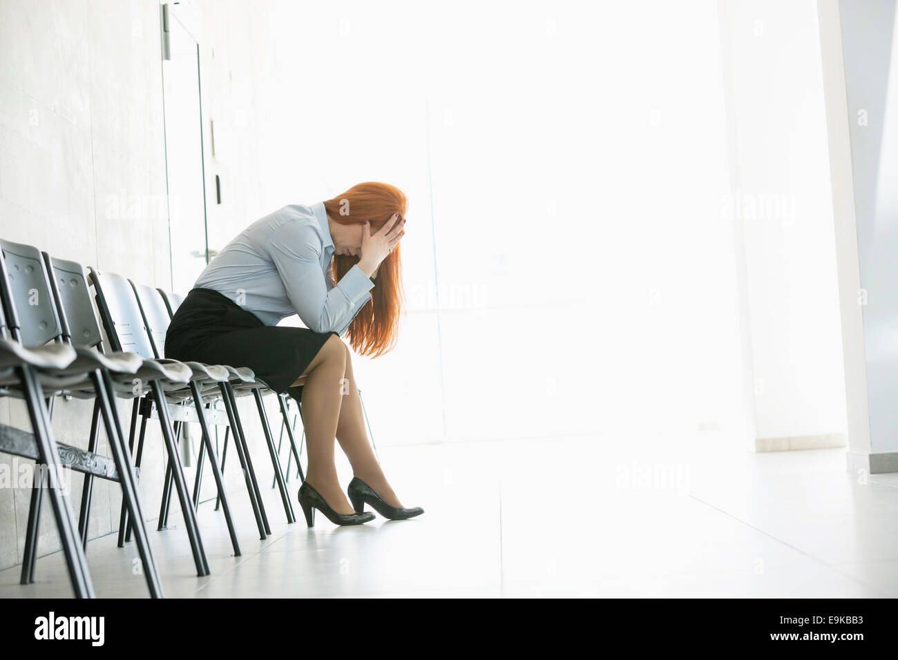 Seitenansicht der erschöpfte Geschäftsfrau sitzend auf Stuhl im Büro Stockfoto