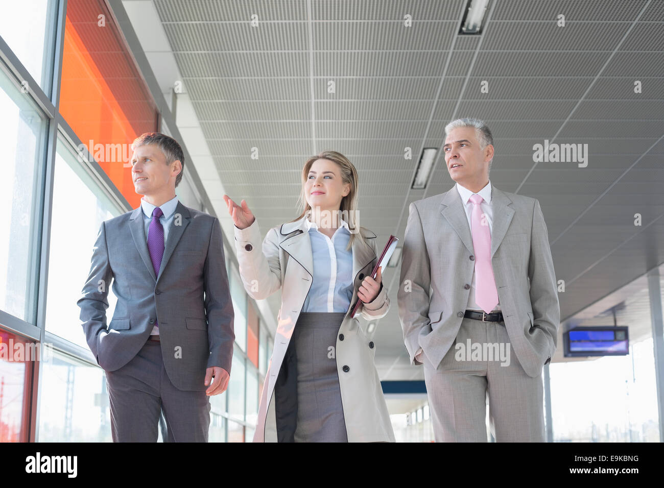 Geschäftsleute sprechen während des Gehens auf Bahnsteig Stockfoto