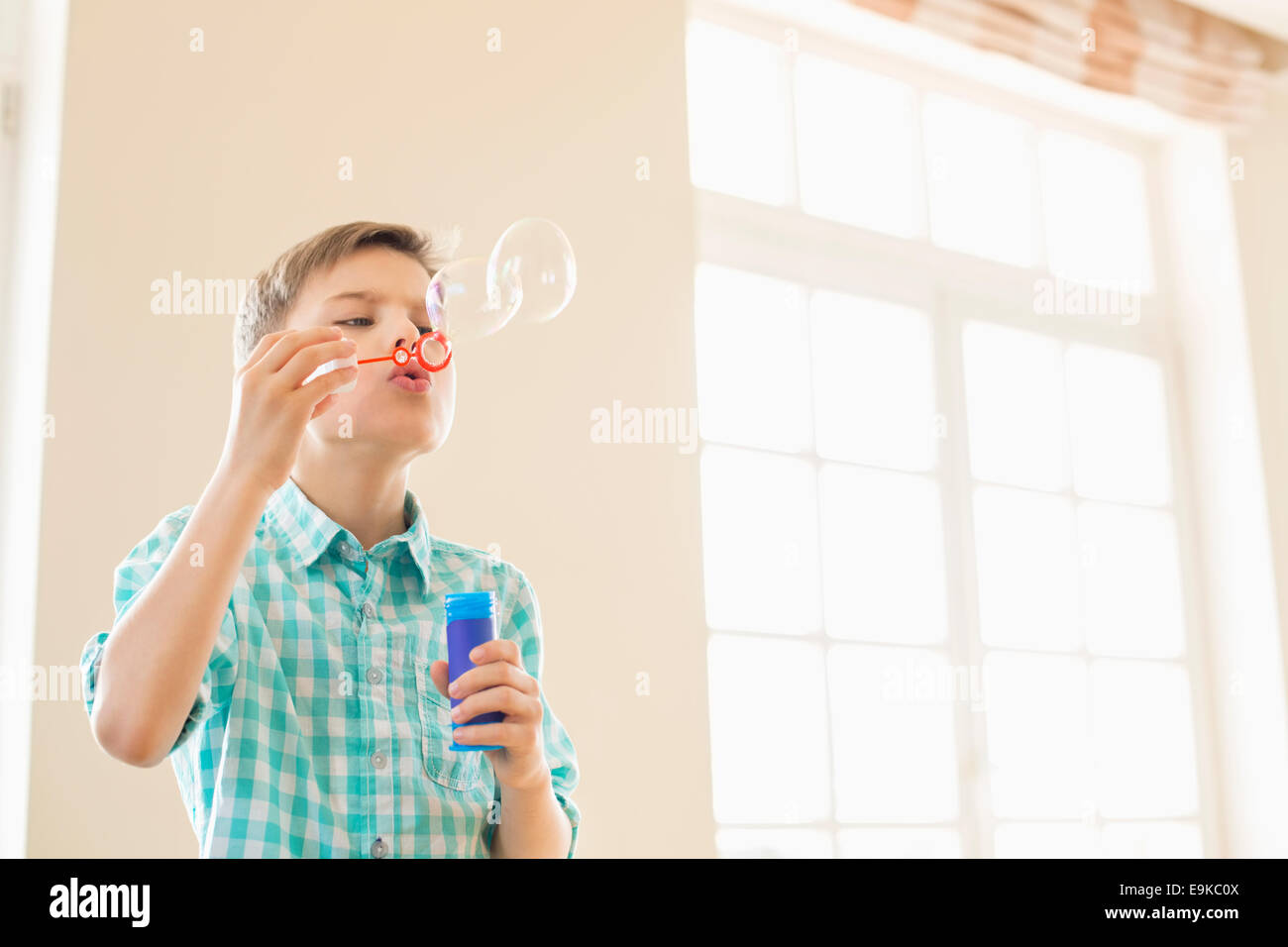 Junge blowing Bubbles zu Hause Stockfoto