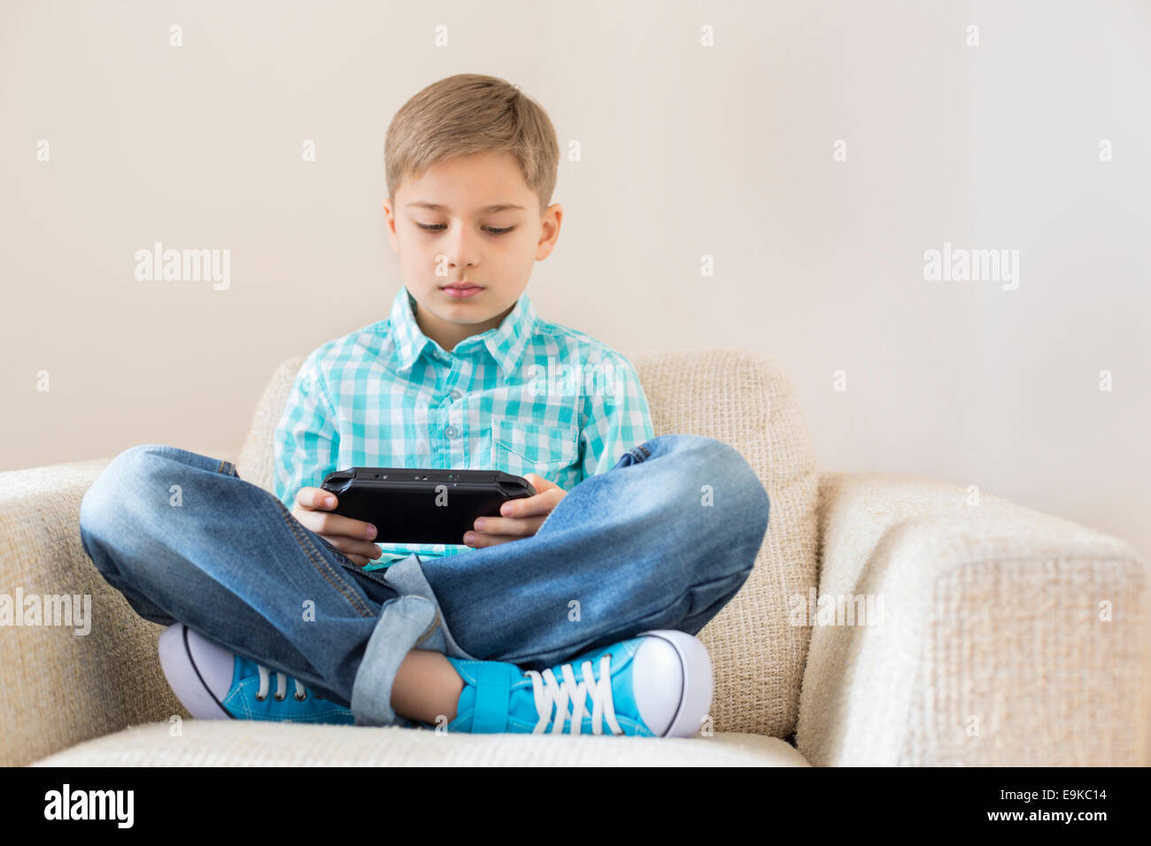 Junge tragbare Videospiel auf sofa Stockfoto