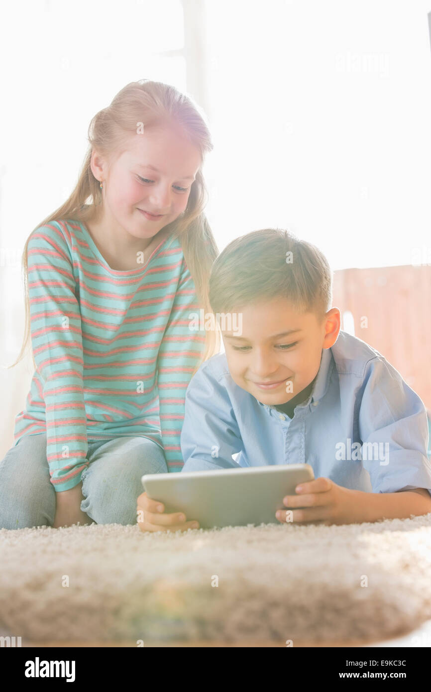 Geschwister mit digital-Tablette auf Boden zu Hause Stockfoto