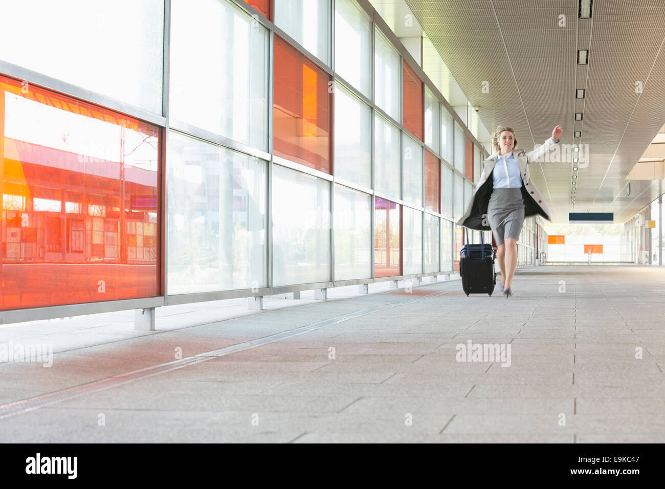 Gesamte Länge der junge Geschäftsfrau mit Gepäck in Bahnhof Rauschen Stockfoto