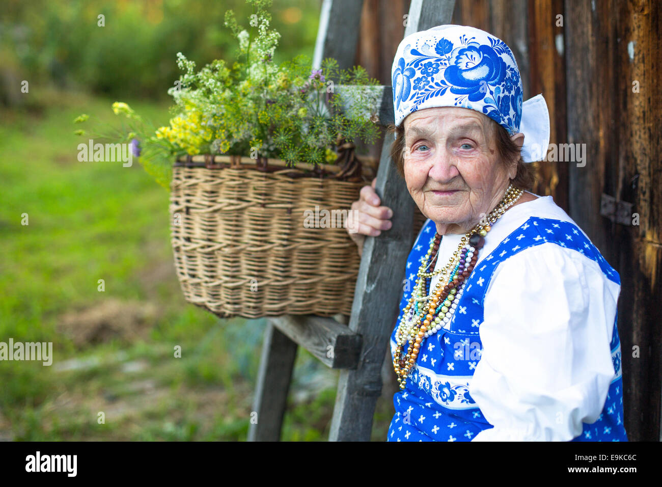 Slawische glücklich Seniorin in ethnische Kleidung im Freien im Dorf. Großmutter. Stockfoto