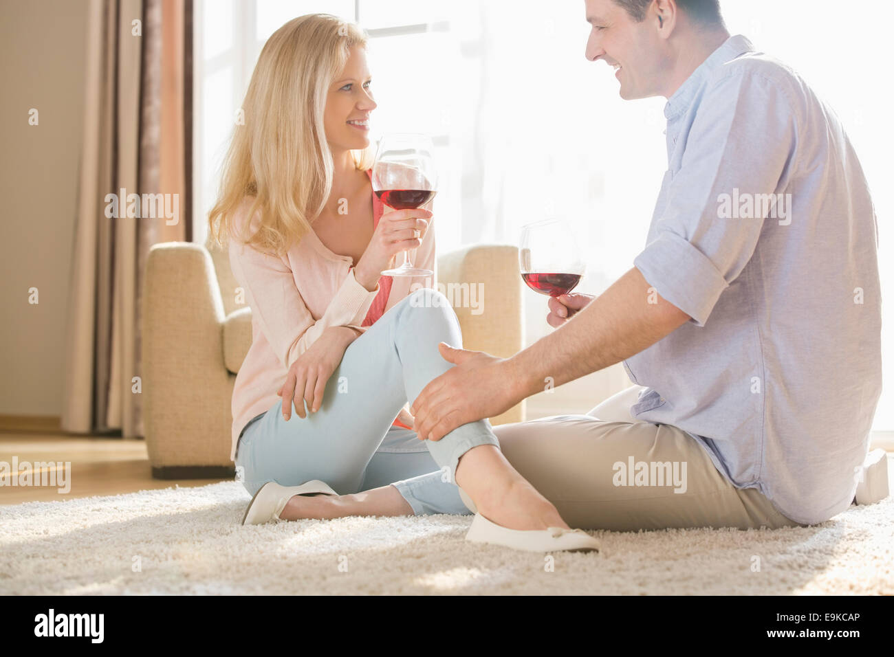 Liebespaar sahen einander beim Trinken von Rotwein zu Hause Stockfoto