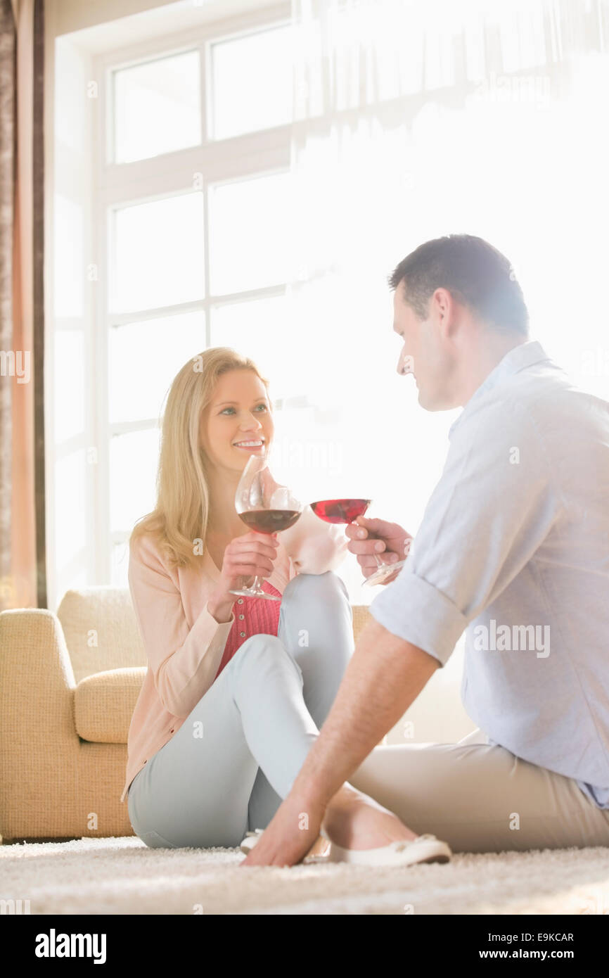 Glückliches Paar sahen einander mit Rotwein zu Hause Stockfoto